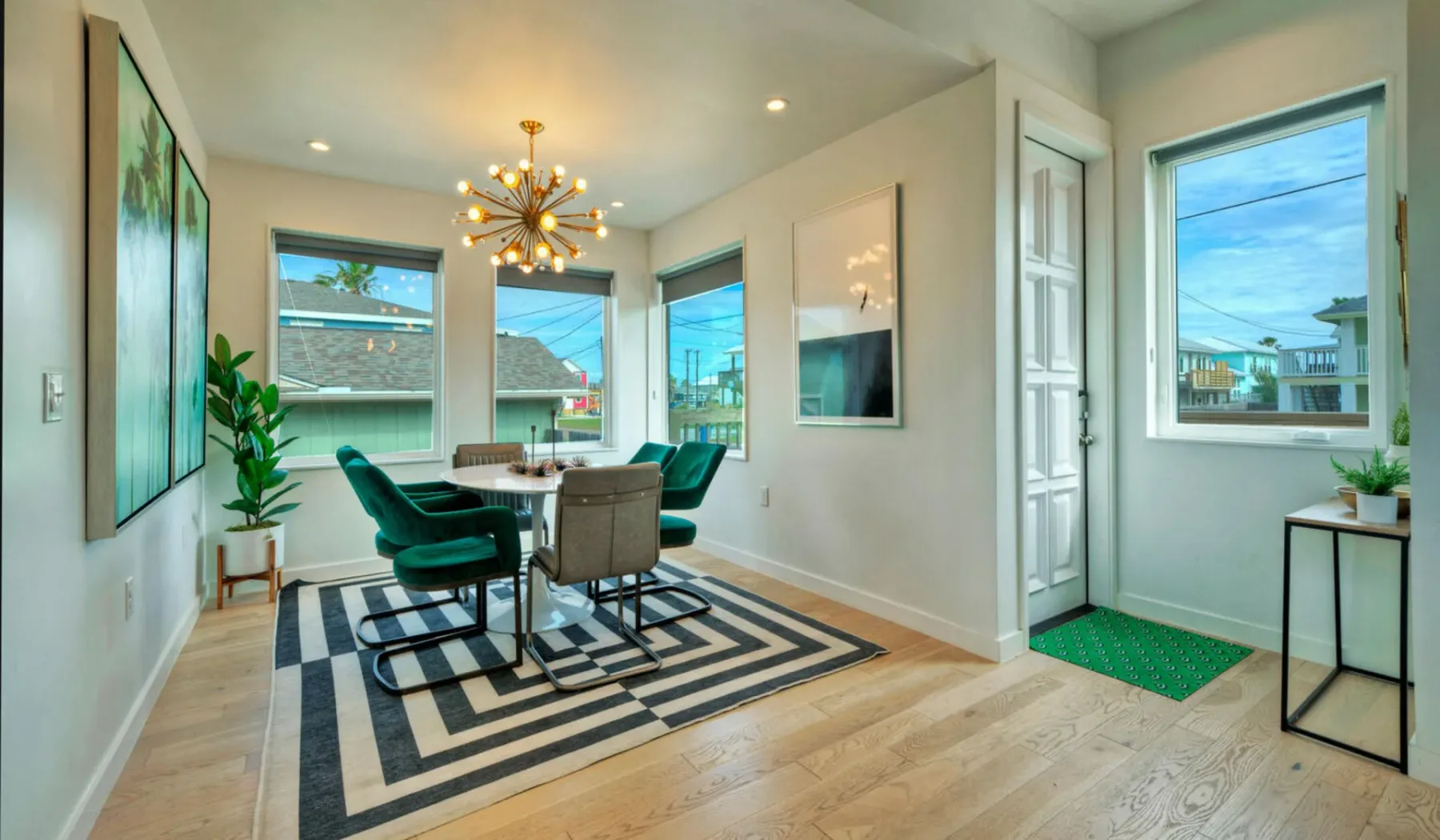 A bright dining area with a table, seating, and large windows.