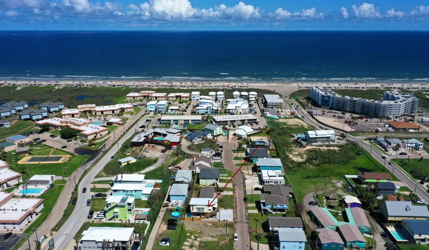 Aerial view of a coastal neighborhood with buildings near the ocean.