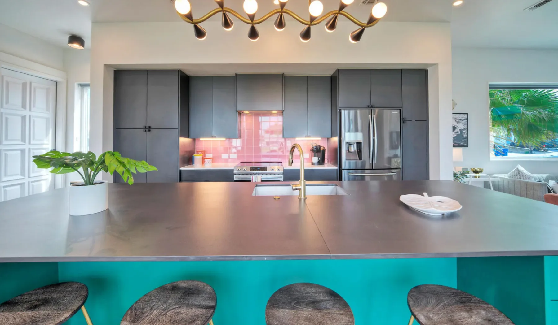 A modern kitchen with dark cabinets, a wide island, and bar seating.