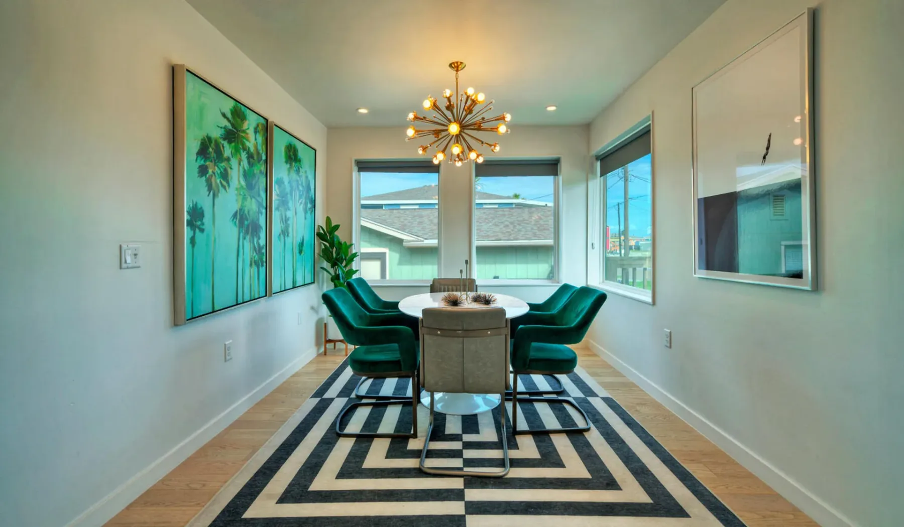 A dining area with a table, seating, large windows, and a geometric rug.