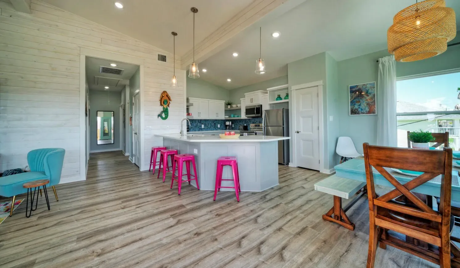 Open-plan kitchen and dining area with a central island and wooden table.