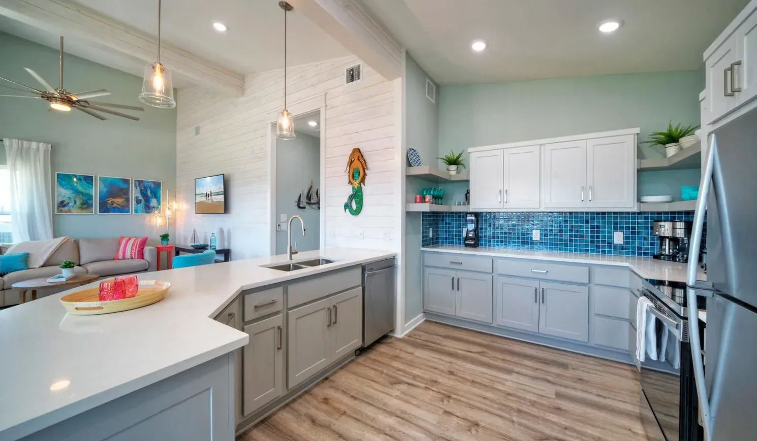 A bright kitchen with white cabinets and a blue tile backsplash.