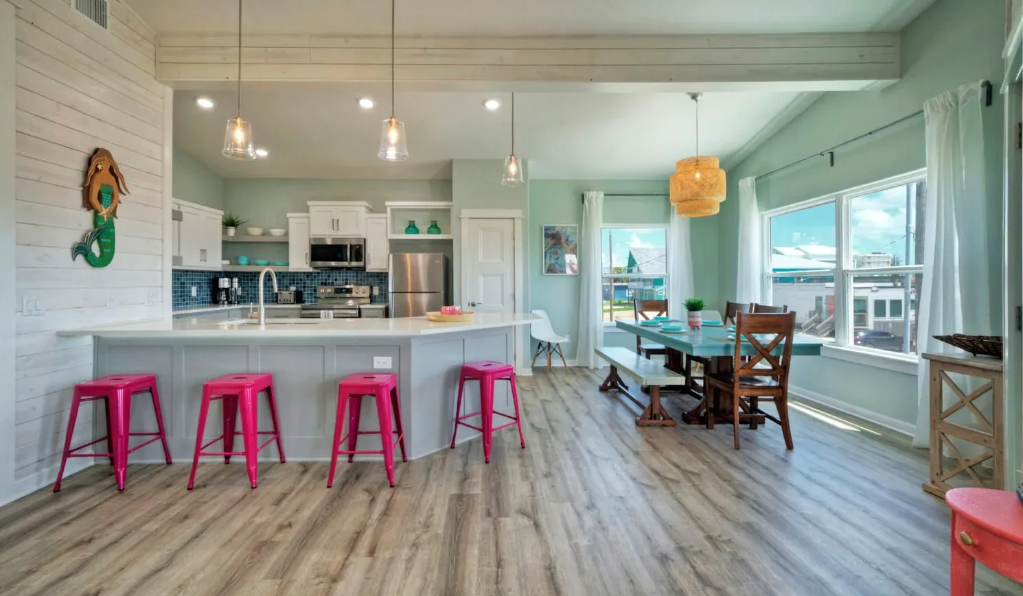 An open kitchen and dining area with a counter and large windows.