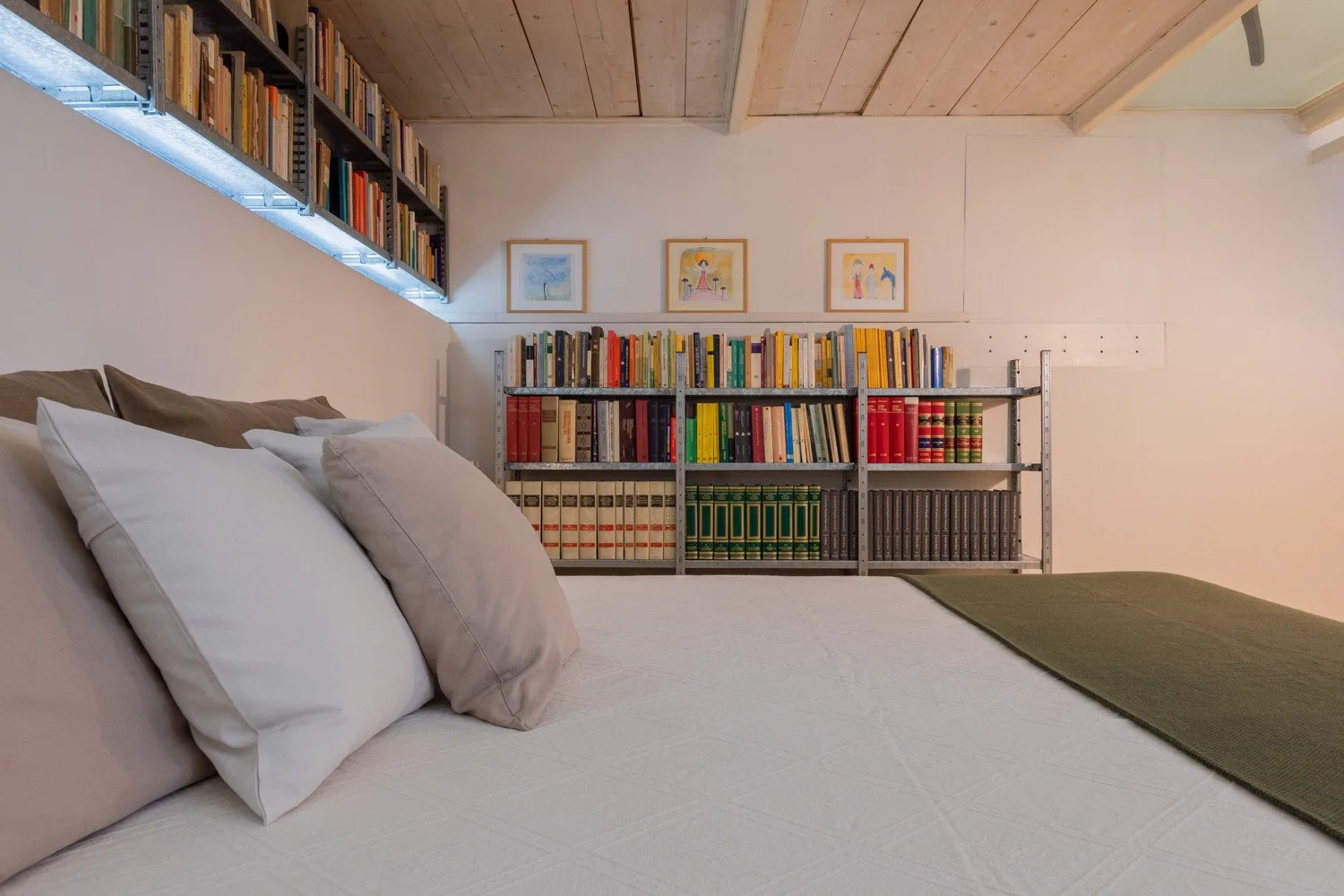 Un dormitorio con una cama y estanterías llenas de libros.