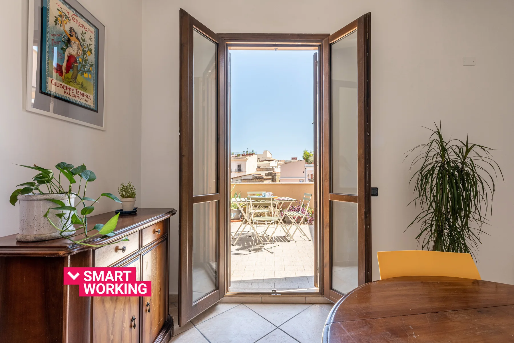 Una zona de comedor se abre a una terraza soleada con asientos al aire libre.