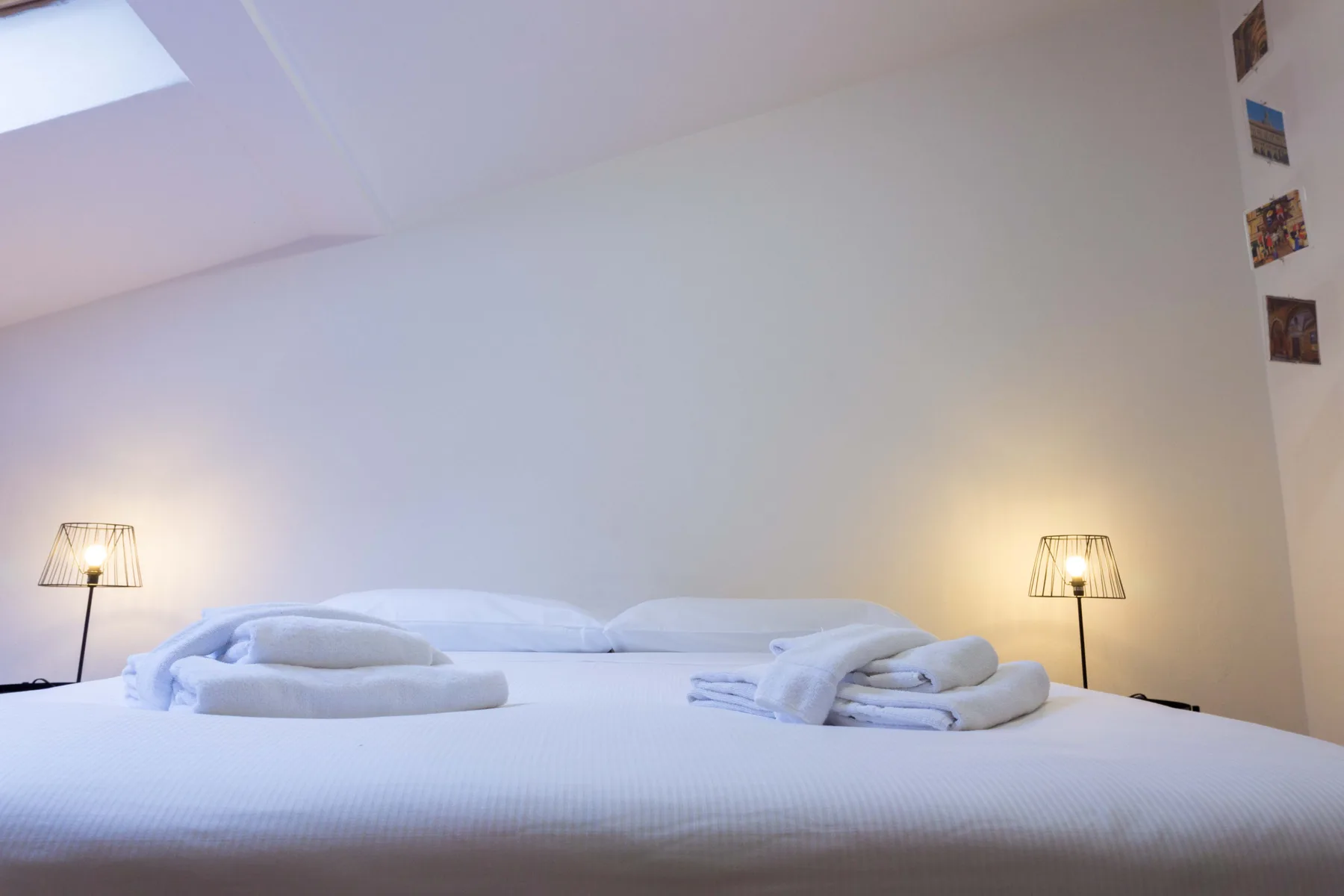 Bedroom with a neatly made bed and matching bedside lamps.