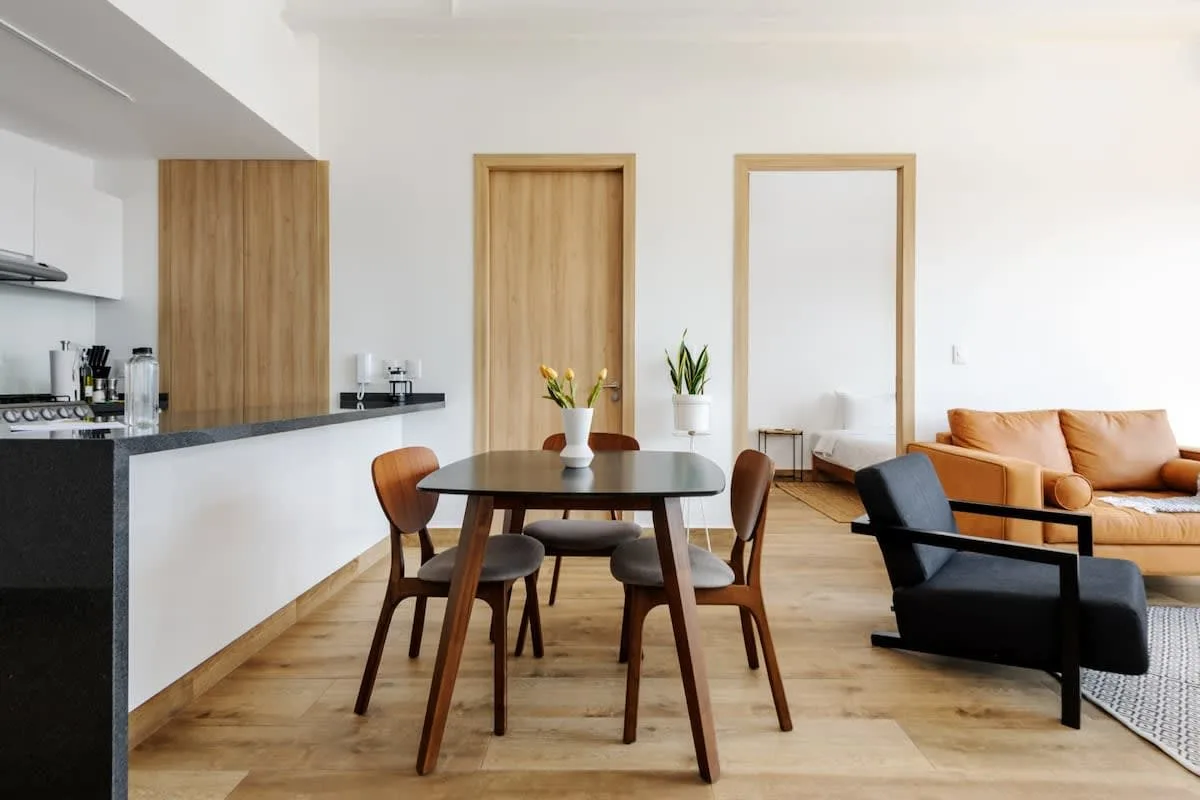 An open-plan dining and living area with a wooden table and seating.