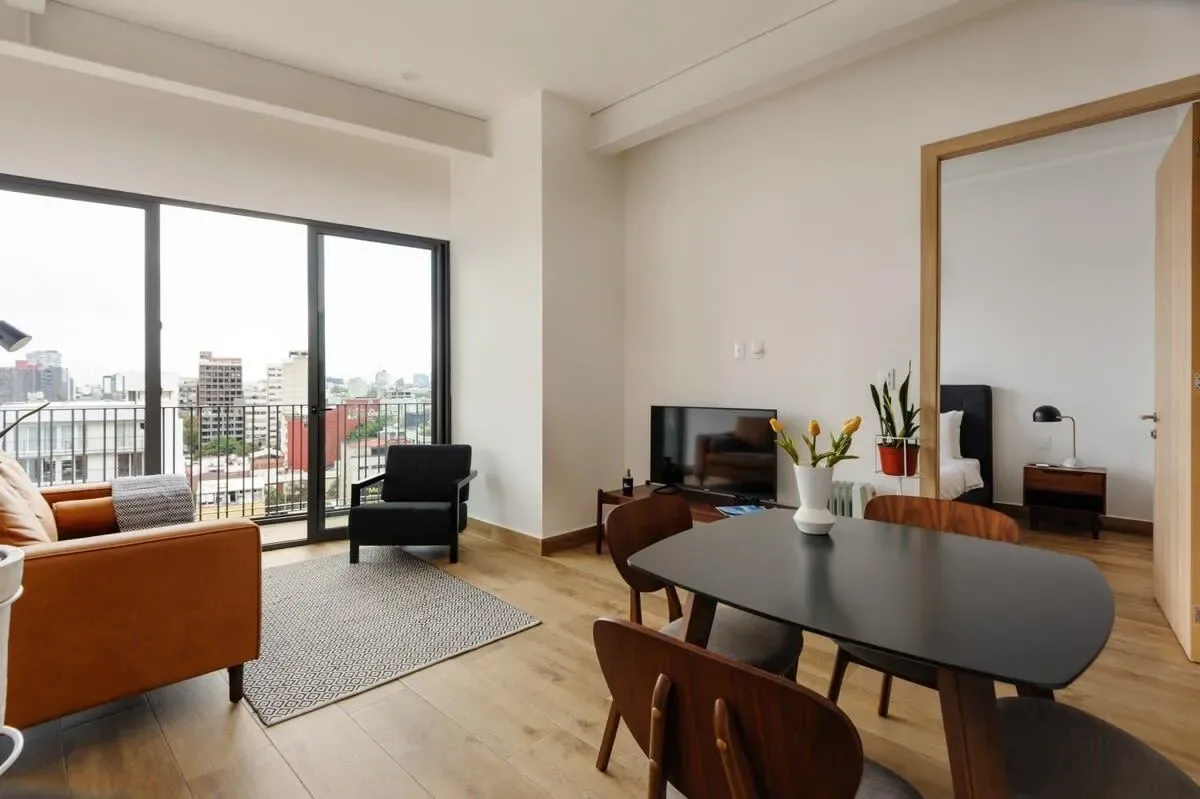 A bright living and dining area with large windows overlooking the city.