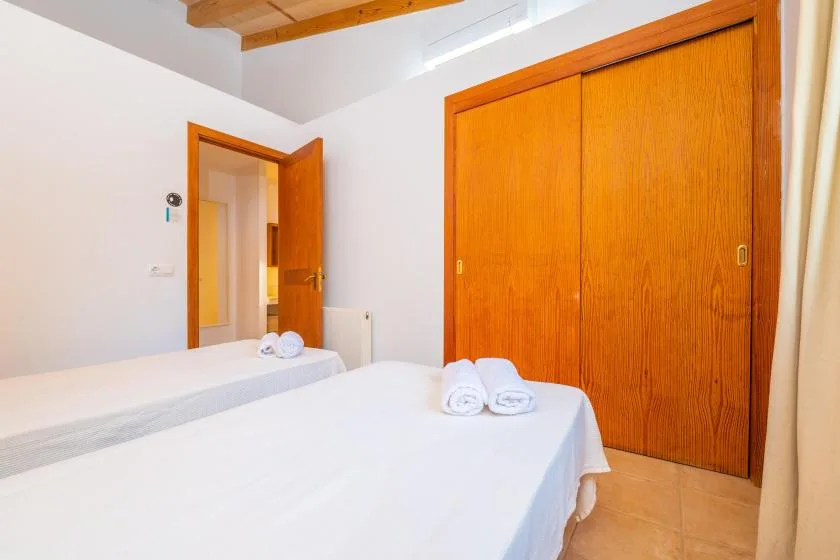 A bedroom with two beds and wooden sliding closet doors.