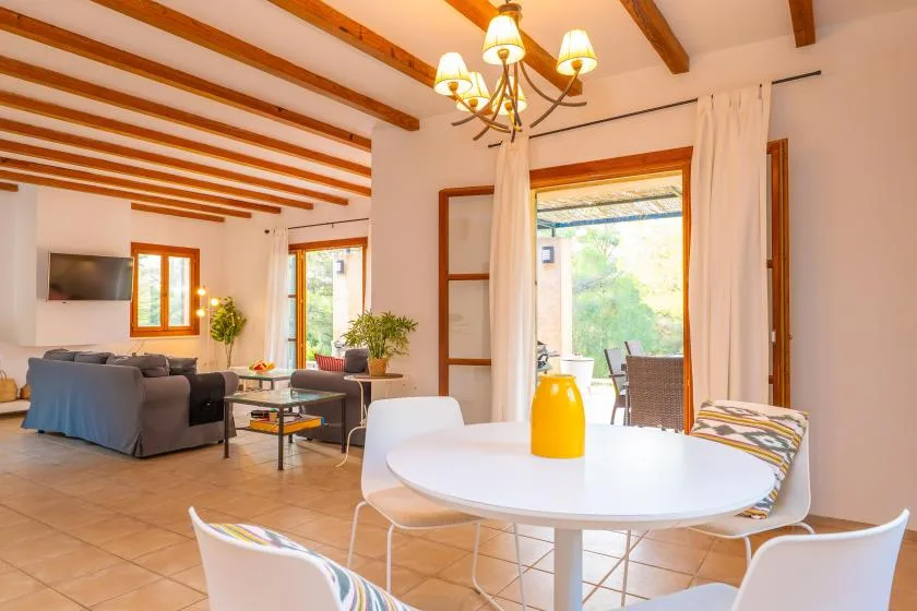 A bright living and dining area opens onto a patio through wide glass doors.