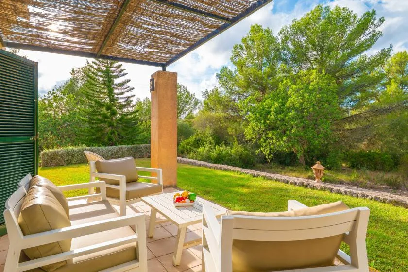 An outdoor patio seating area overlooks a green lawn and trees.