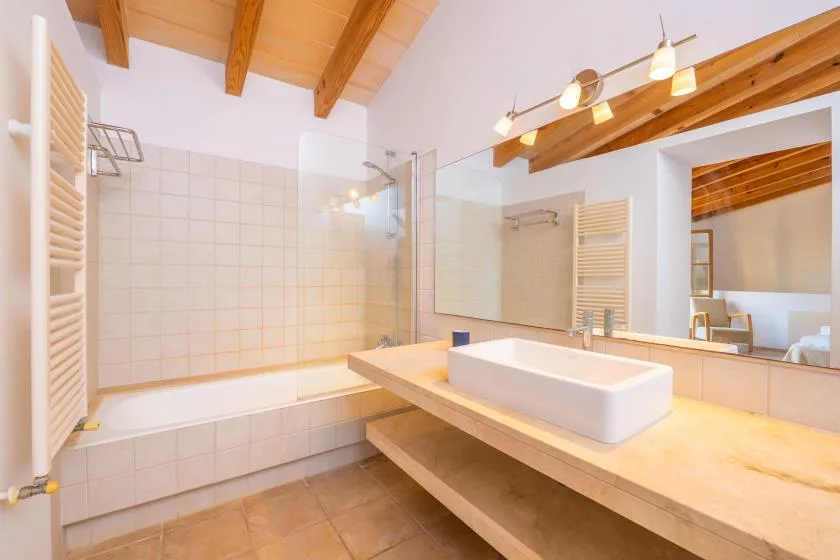 A tiled bathroom with a bathtub and a large vanity.