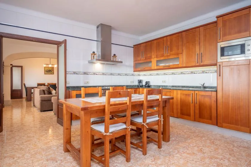 A kitchen and dining area with wooden cabinets and a dining table.