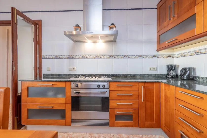 A kitchen with wooden cabinets, a stovetop, and an oven.