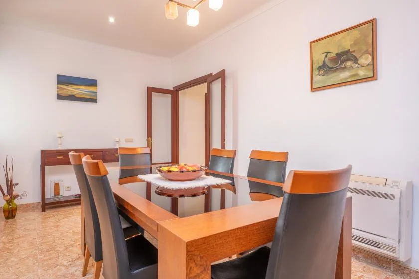Dining room with a wooden table and chairs beneath framed wall art.