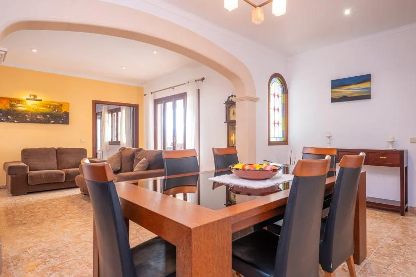 A dining area with a wooden table and seating beside a living area.
