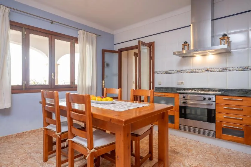 A kitchen and dining area with a wooden table and chairs.