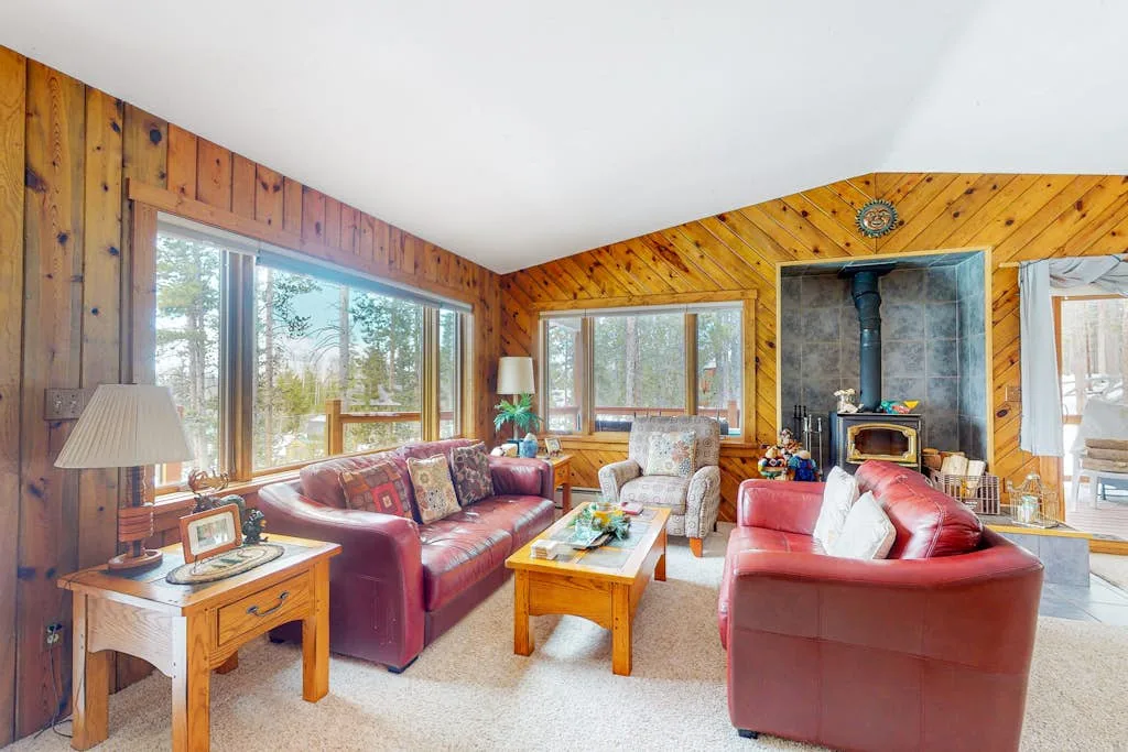 A wood-paneled living room with seating arranged around a coffee table.