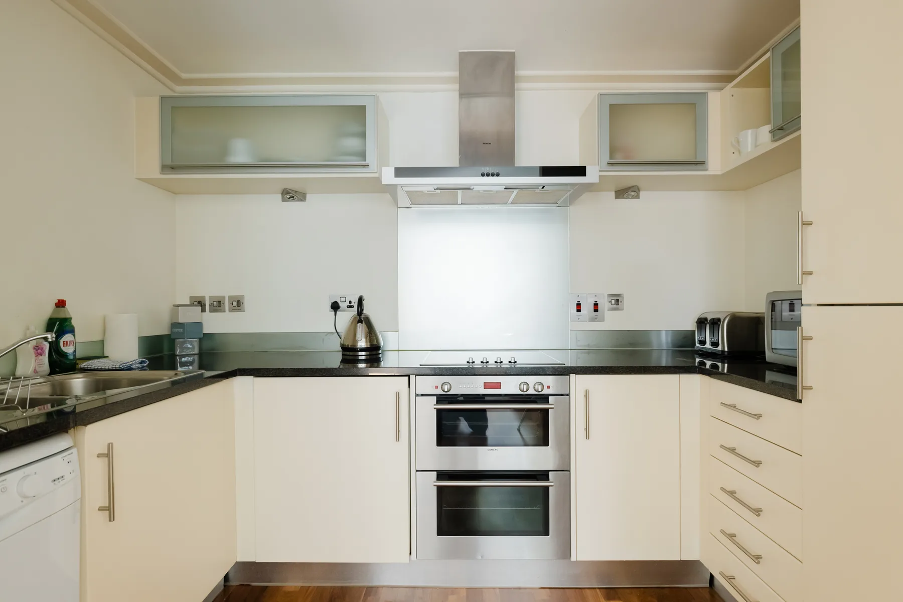 A bright kitchen with built-in cabinetry, a cooktop, and an oven.