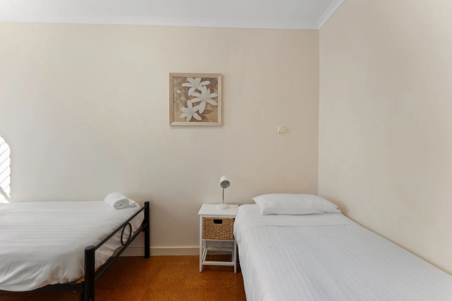 A bedroom with two single beds and a small bedside table.