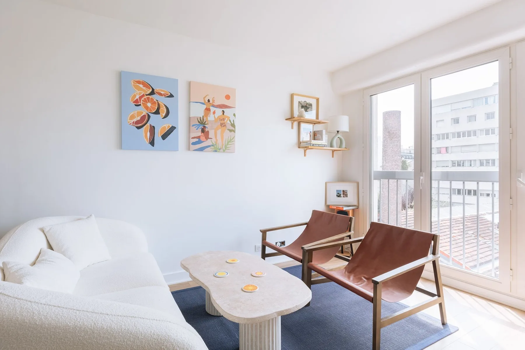 A bright living room has seating beside large windows.