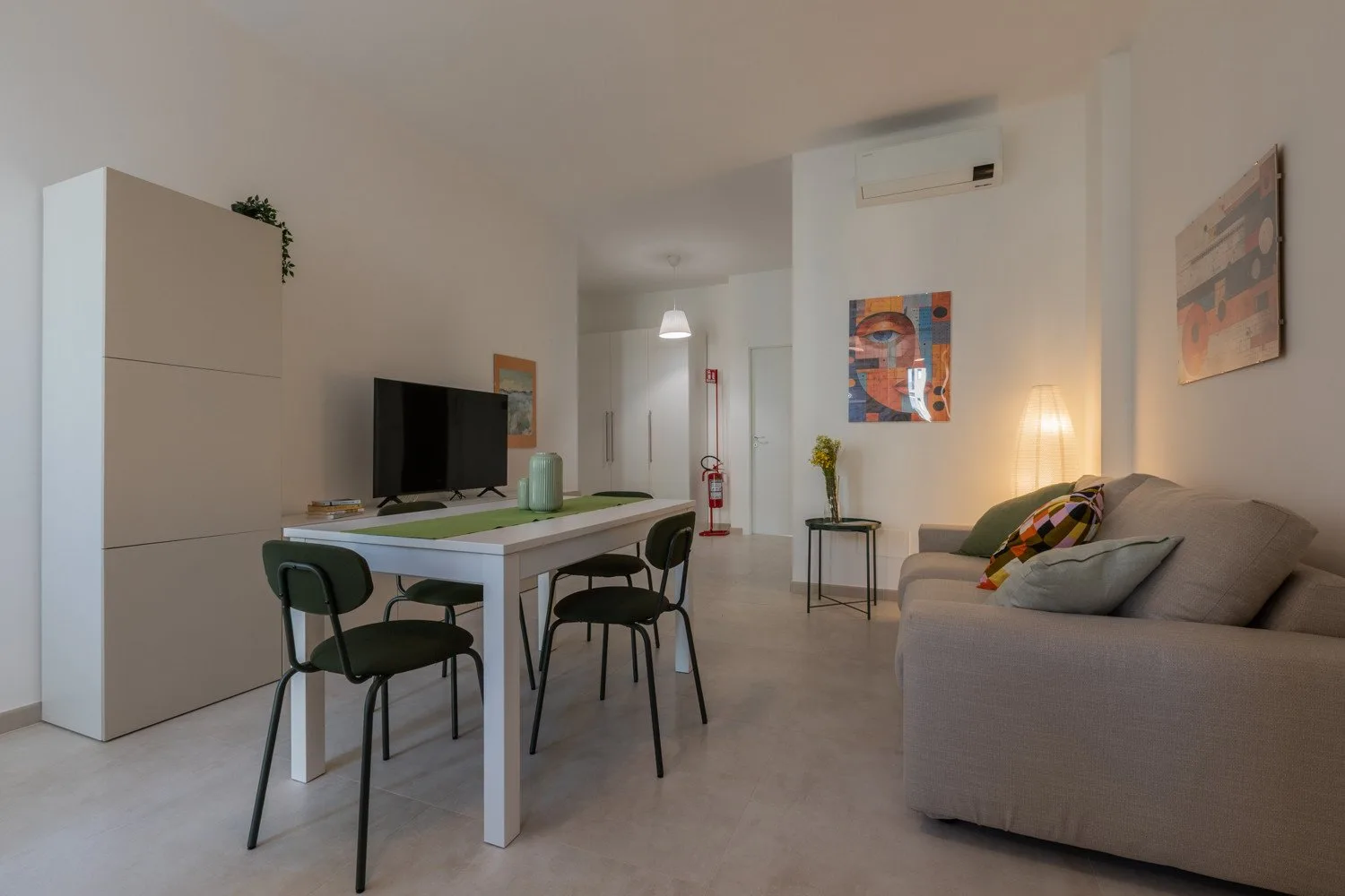 A living and dining area with a table, chairs, and sofa.