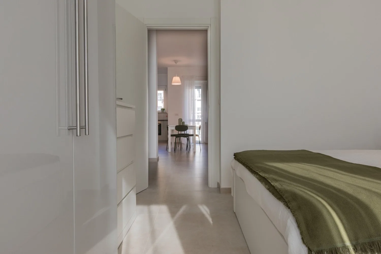 A bedroom opens onto a dining area through a doorway.