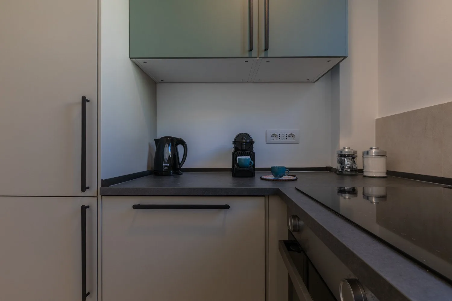 A compact kitchen with dark counters and small appliances.