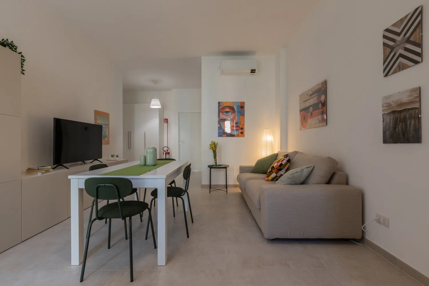 A living room with a sofa, television, and small dining table.