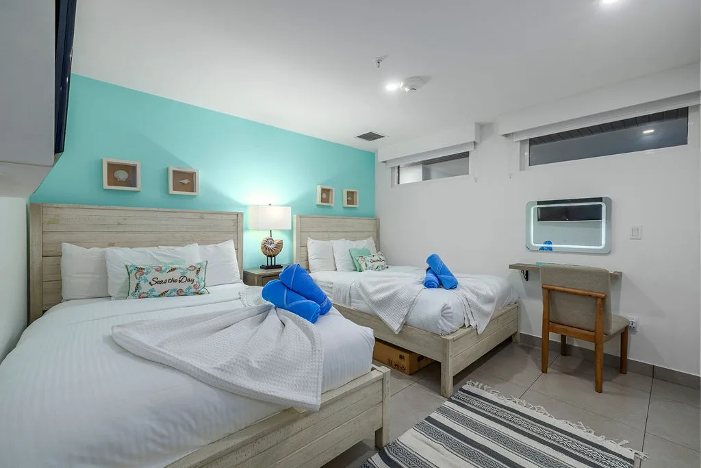Unwind in your bright, beachy bedroom with two plush beds, cheerful turquoise accents, and cozy touches that invite you to kick back and relax.