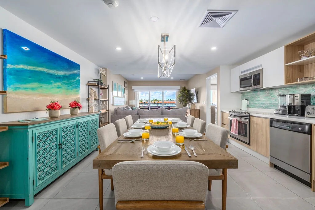 Gather around this bright, coastal-inspired space where every meal feels like a celebration. The open kitchen and inviting dining table make your vacation mornings effortless and memorable.