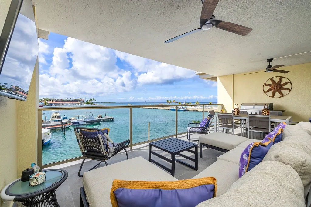 Breathtaking waterfront balcony with turquoise sea views, cozy lounge seating, and tropical breezes. Your perfect spot to relax and soak in the marina scenery.
