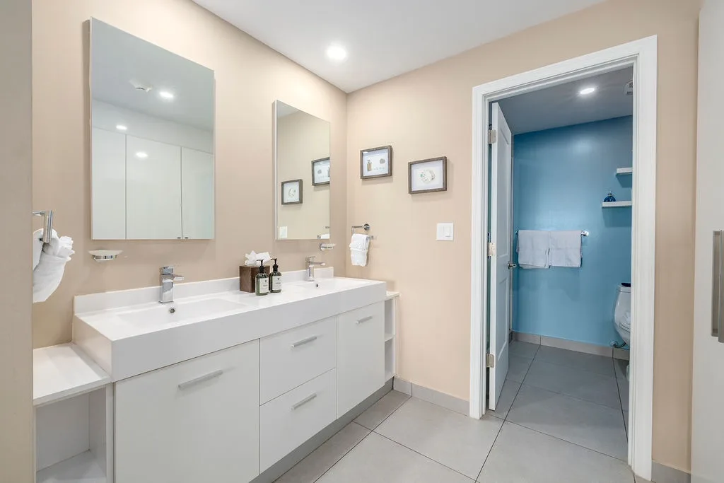 Refresh in your spacious dual-sink bathroom with crisp white counters and modern fixtures, plus a private toilet area for added convenience.