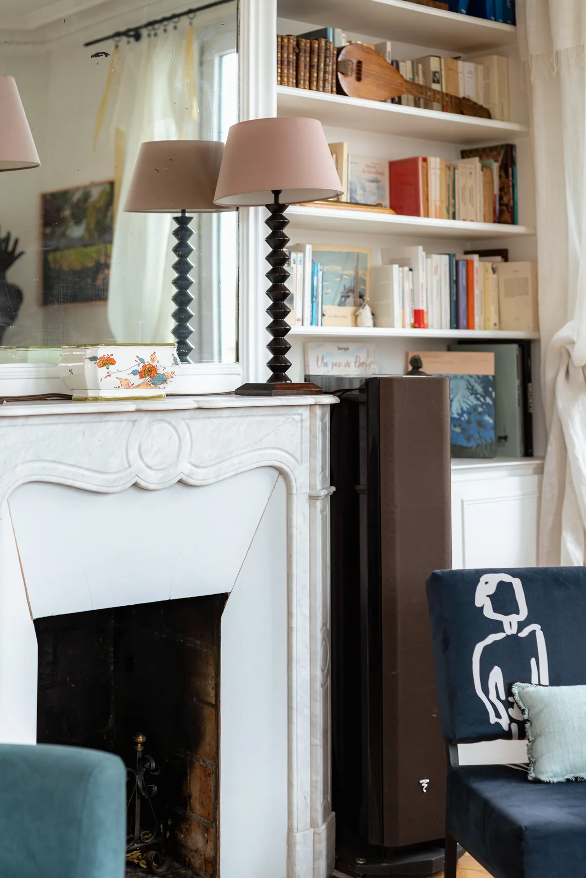 A living room with a fireplace, bookshelves, and a seating area.