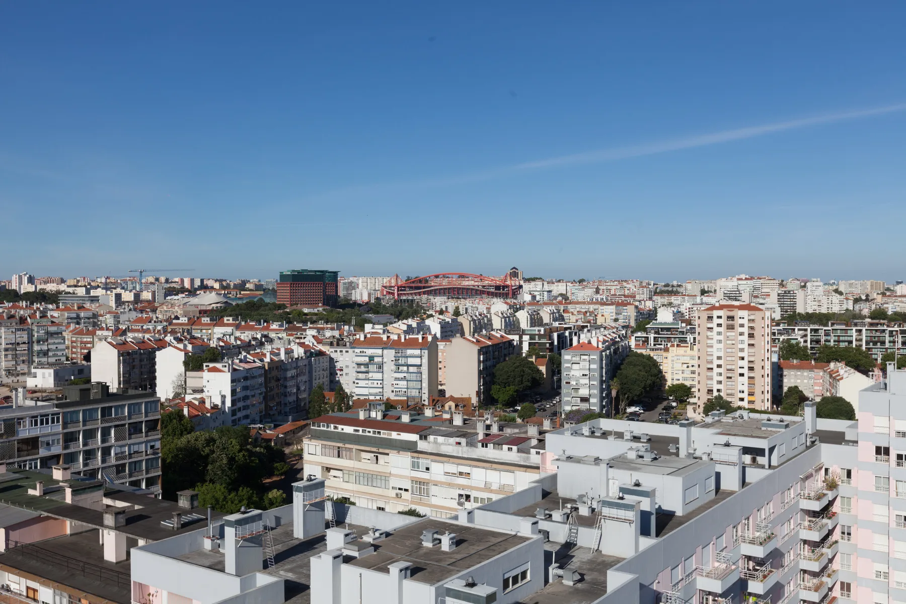 Un horizonte urbano con numerosos edificios de apartamentos bajo un cielo azul despejado.