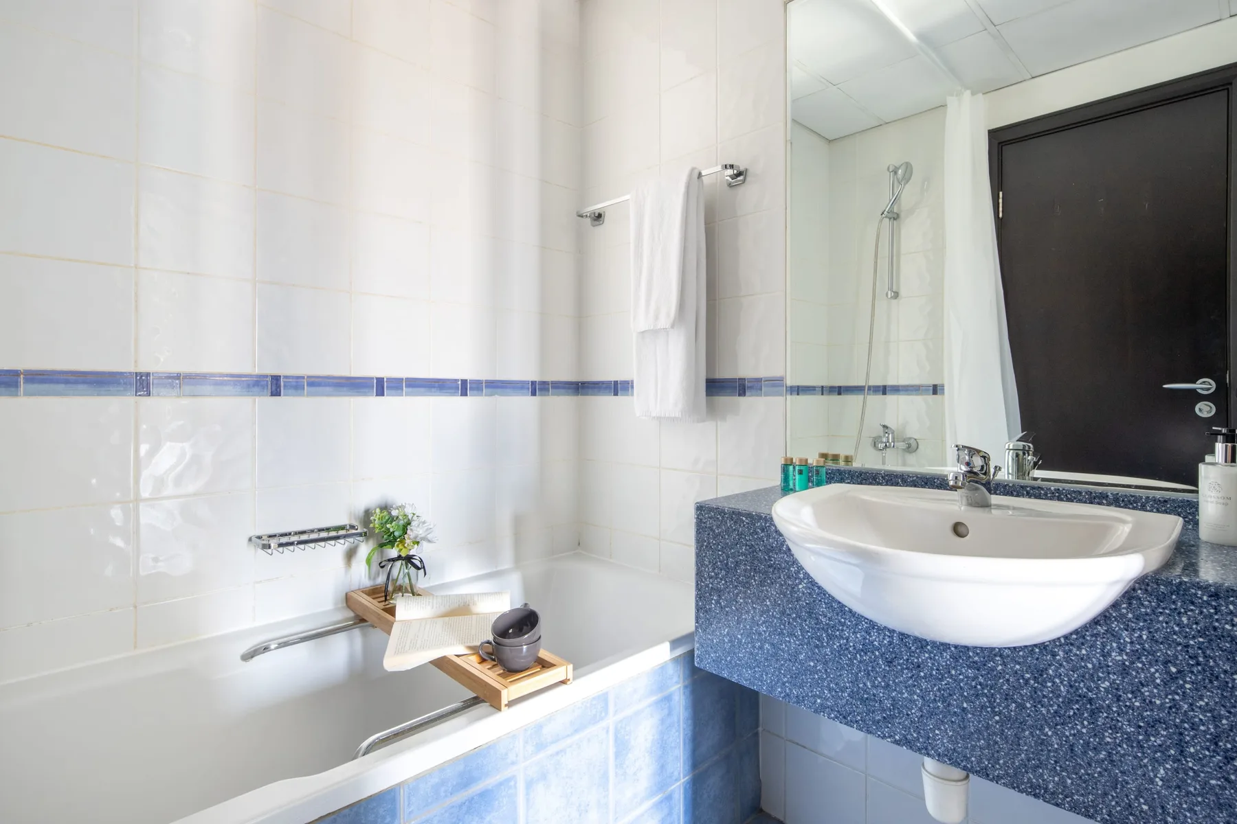 A tiled bathroom with a bathtub and a sink.