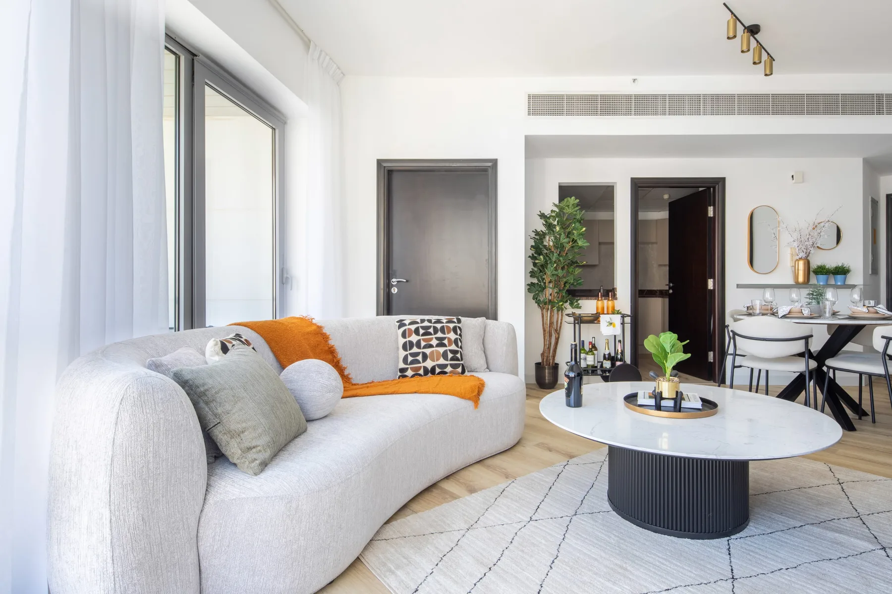 A bright living room with a curved seating area and a round coffee table.