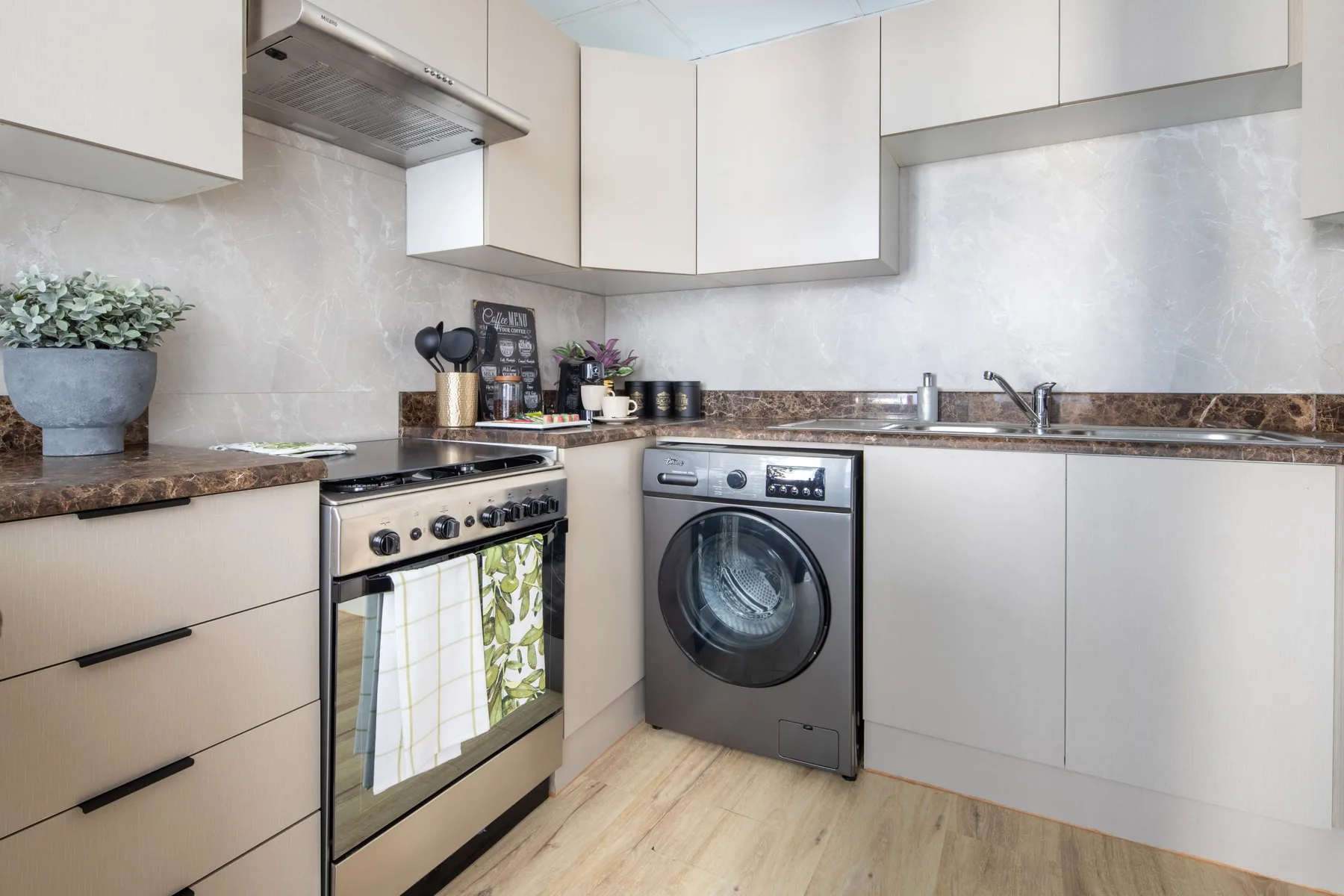 A compact kitchen with an oven, washing machine, and countertop.