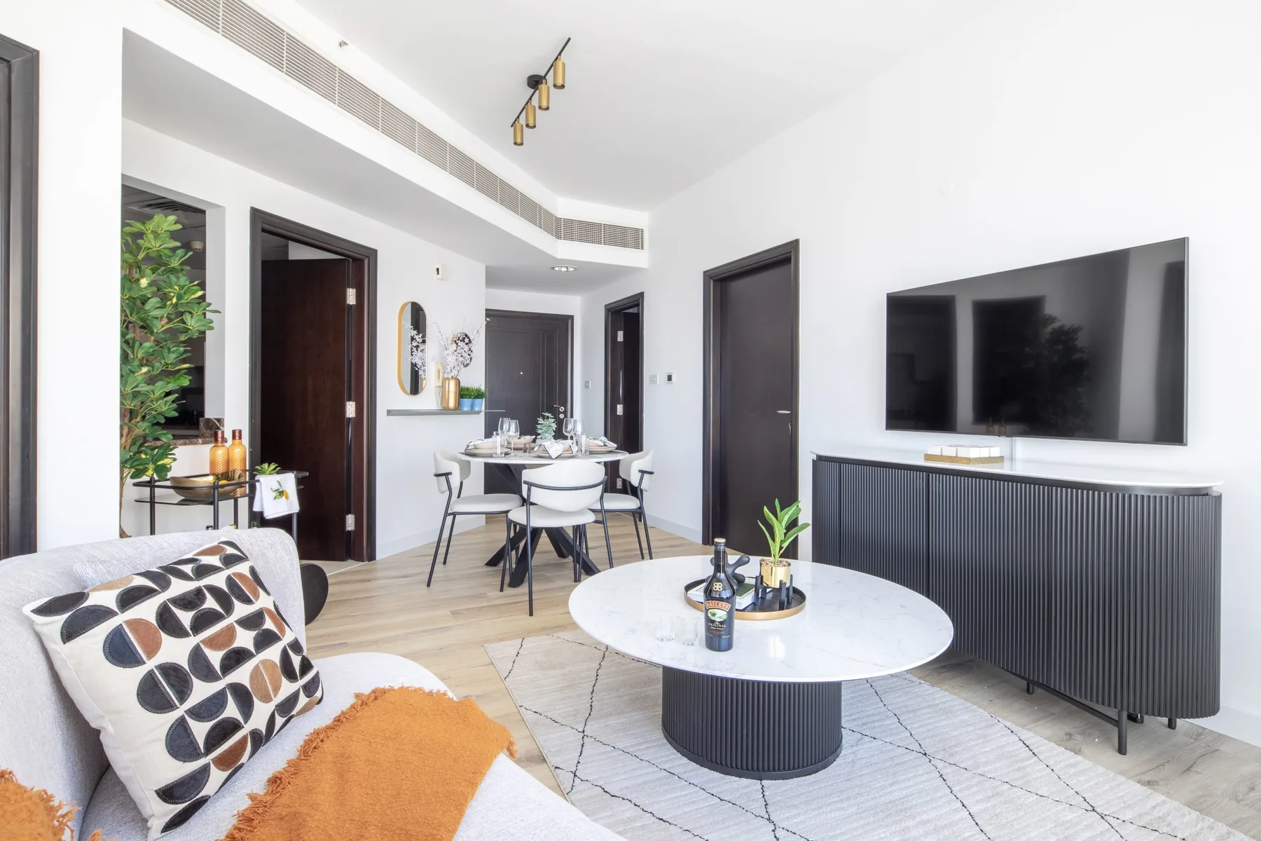 A bright living and dining area with a round coffee table and dining seating.