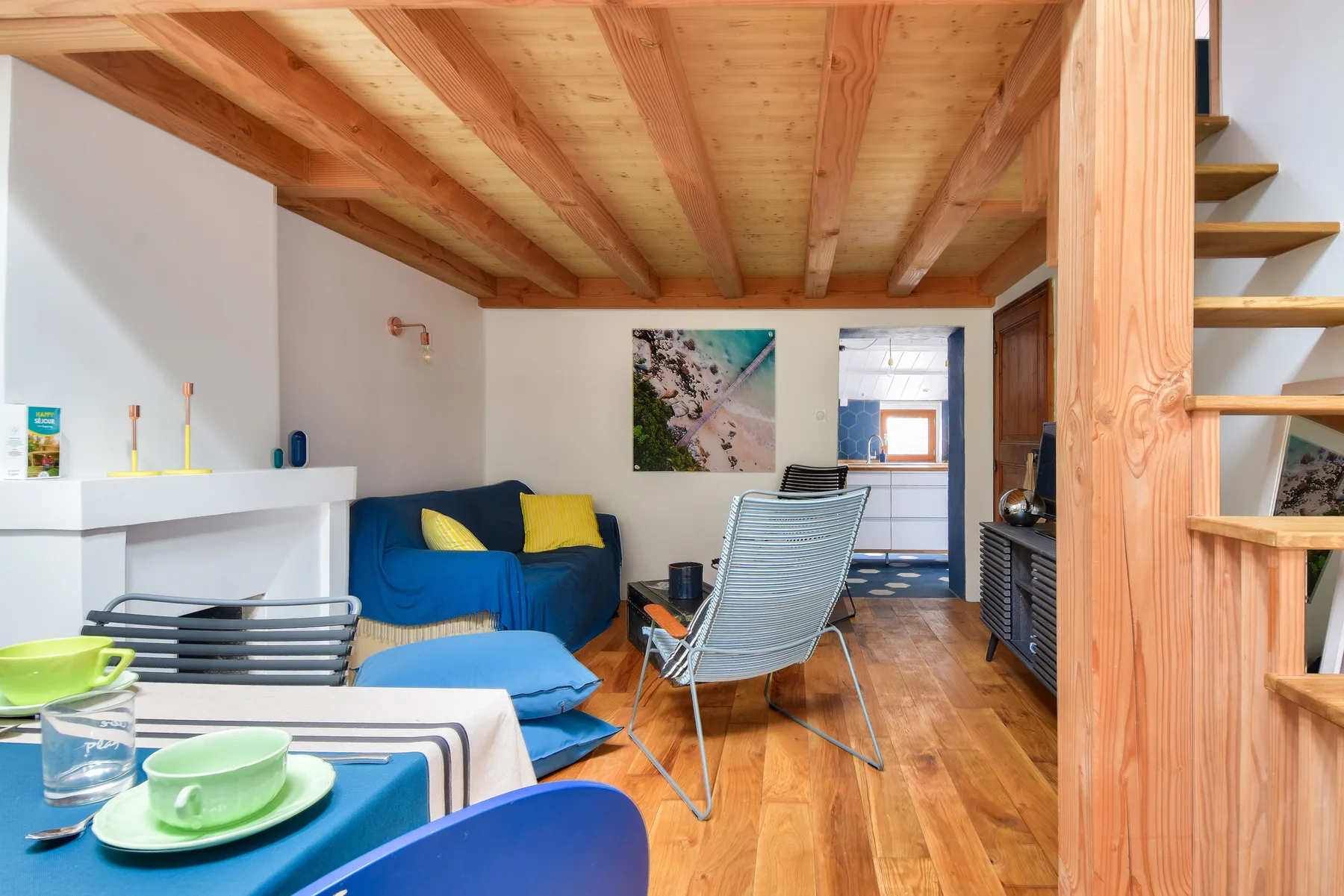 Living room with blue seating and a wooden staircase.