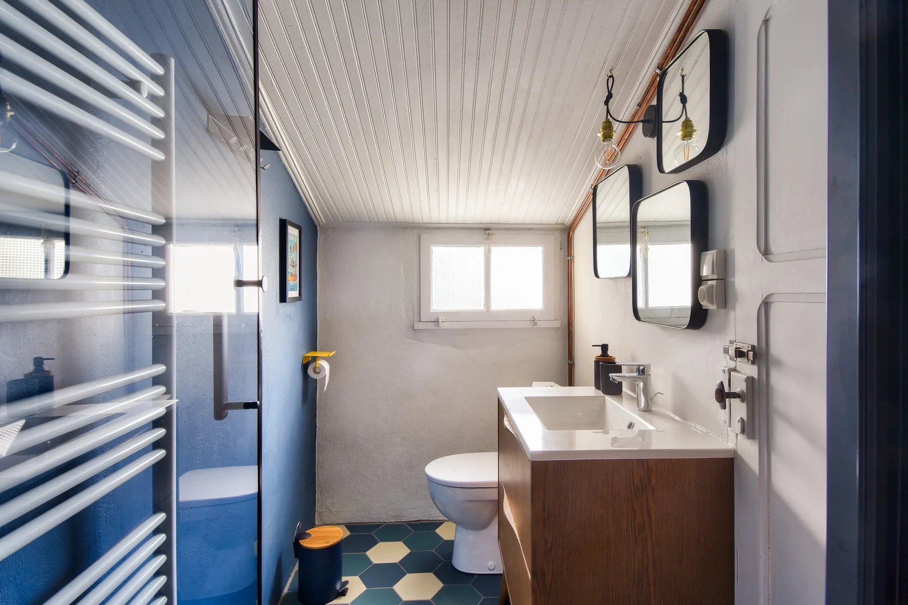 A bathroom with a sink, toilet, and blue shower enclosure.