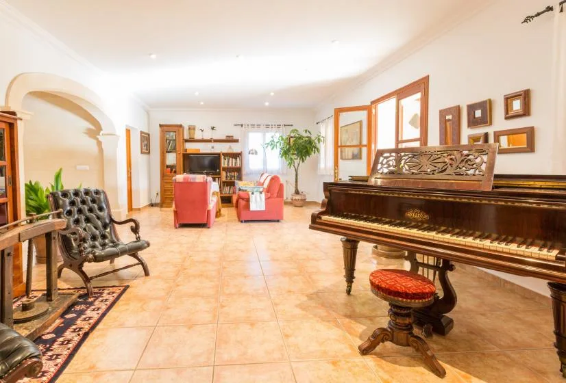 Una sala luminosa con un piano de cola y asientos.