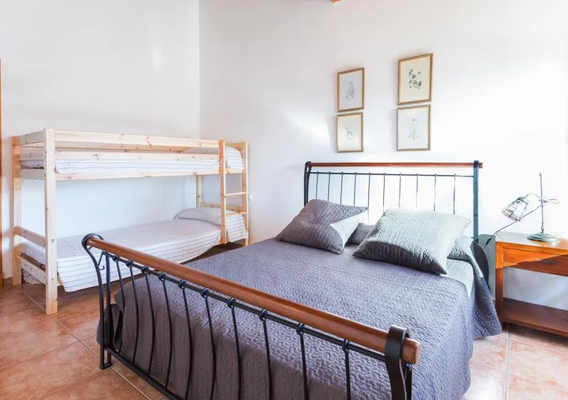 Un dormitorio con una cama doble y una litera de madera.