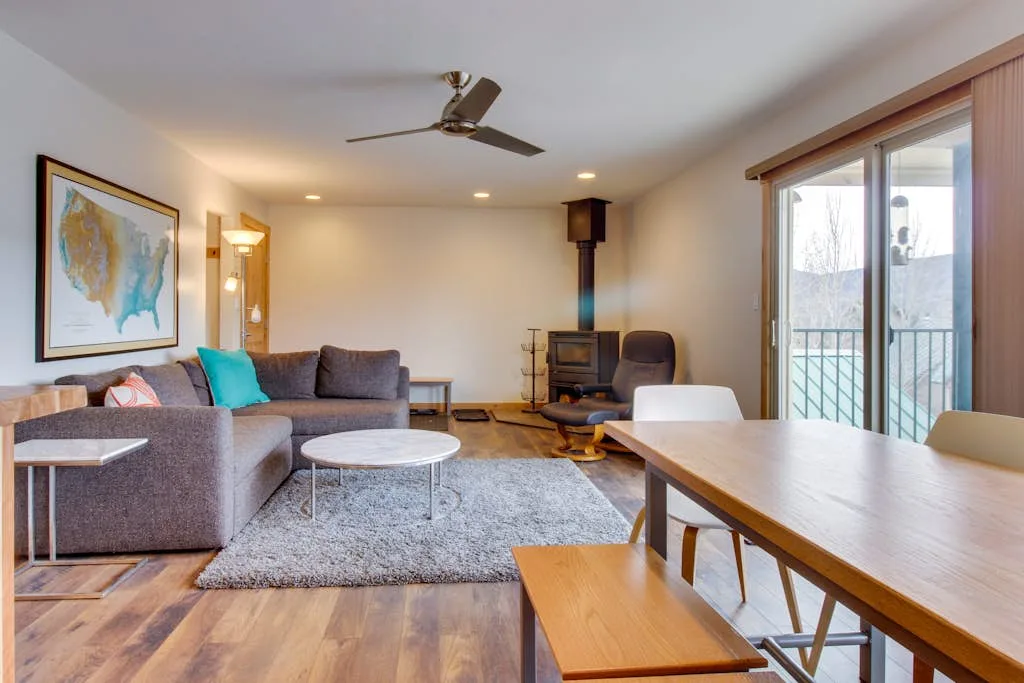 A living room with seating, a wood stove, and a sliding glass door.