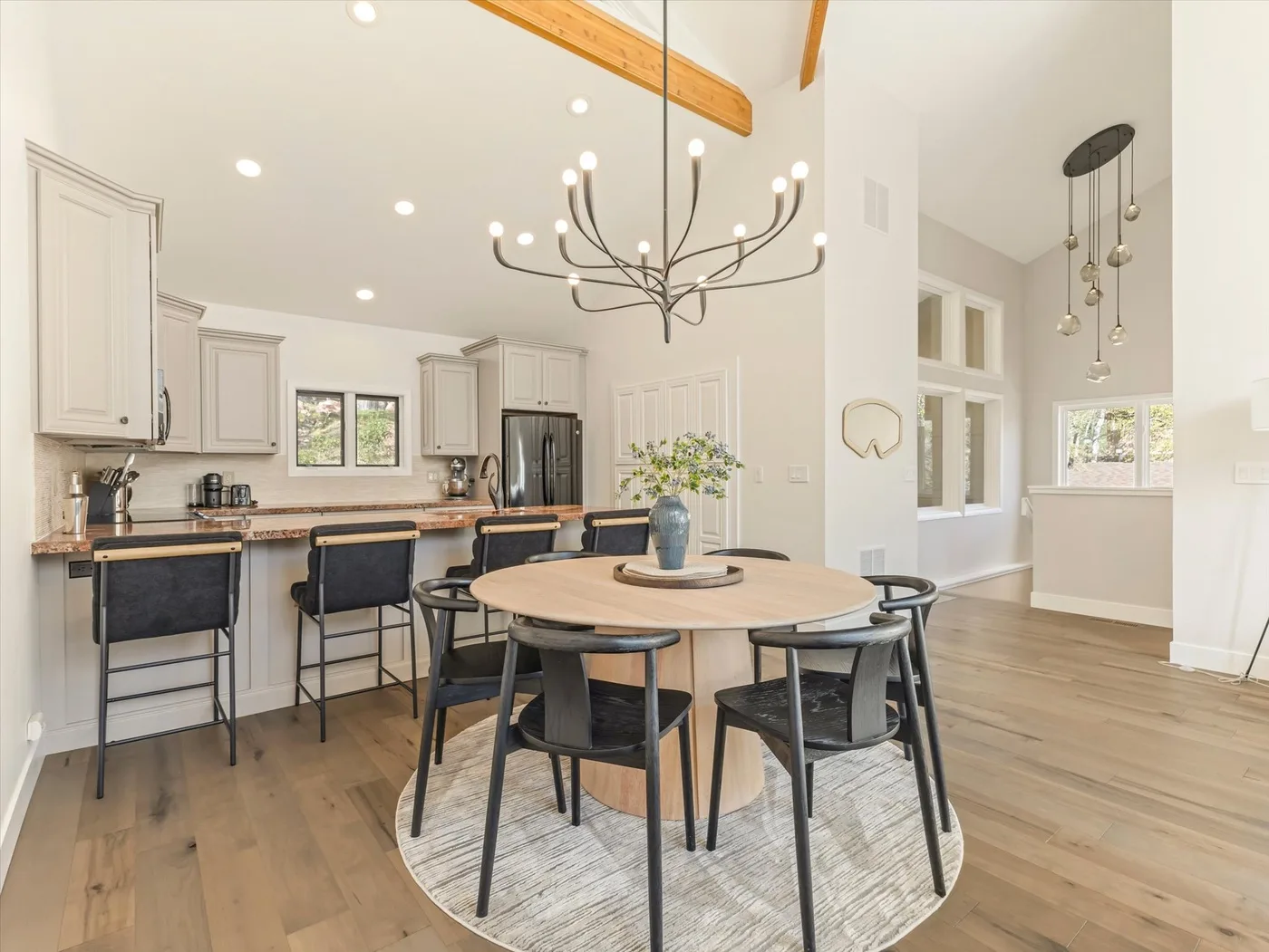 A dining area with a round table and an open kitchen in the background.