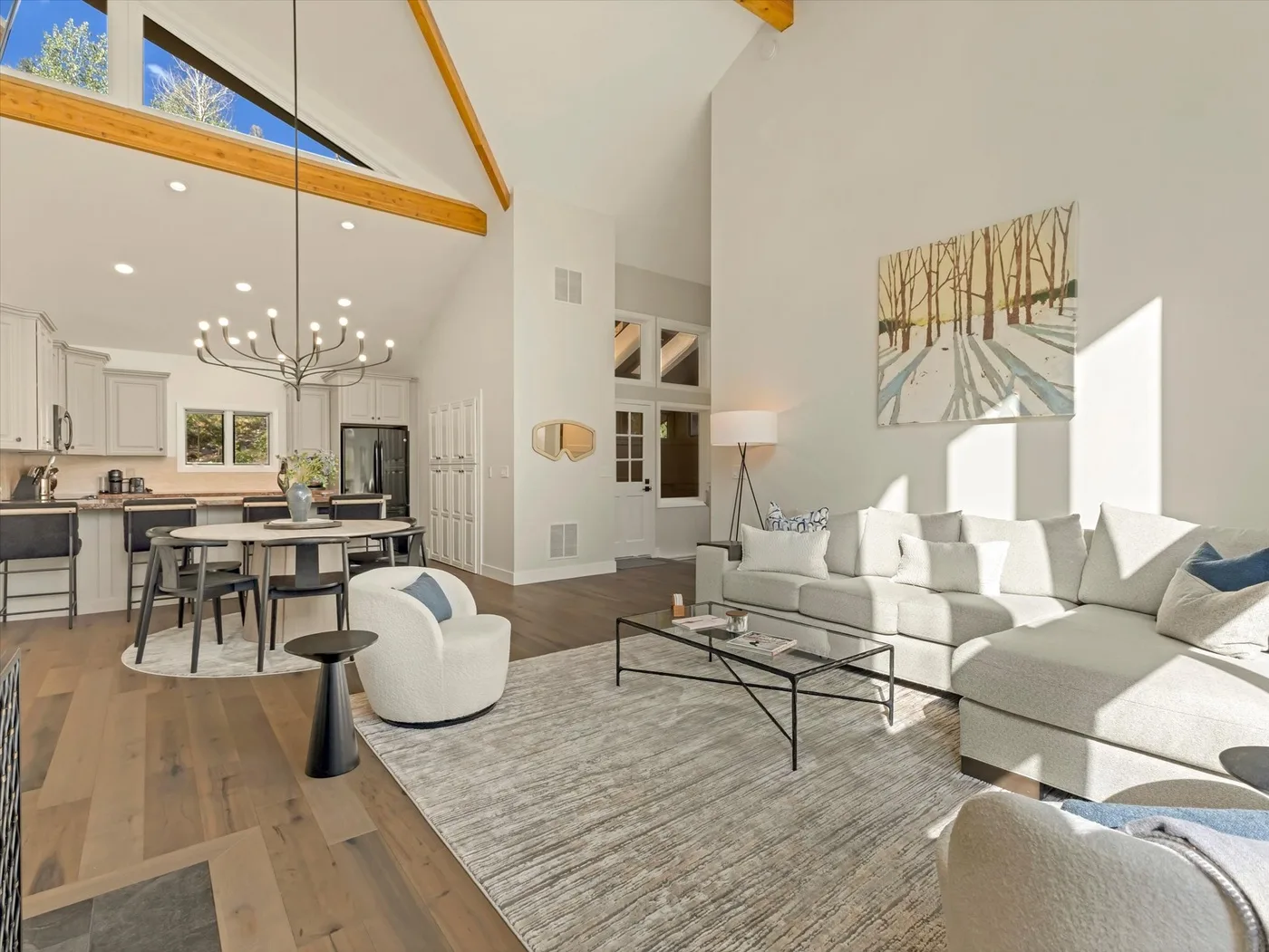 An open-plan living and dining area with a kitchen and large windows.