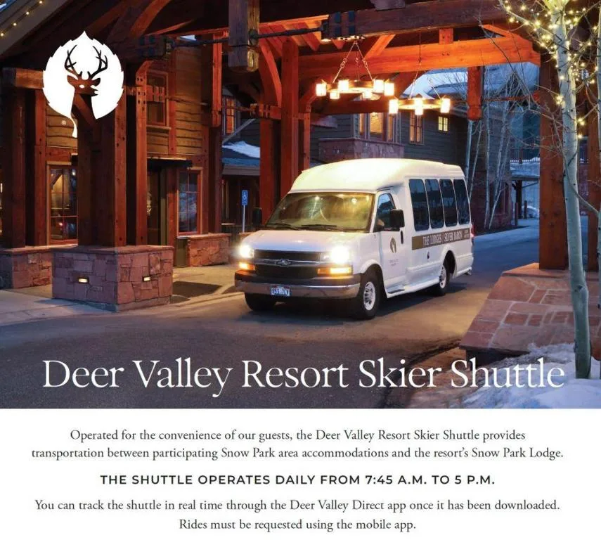 A white shuttle van is parked outside a warmly lit lodge entrance.