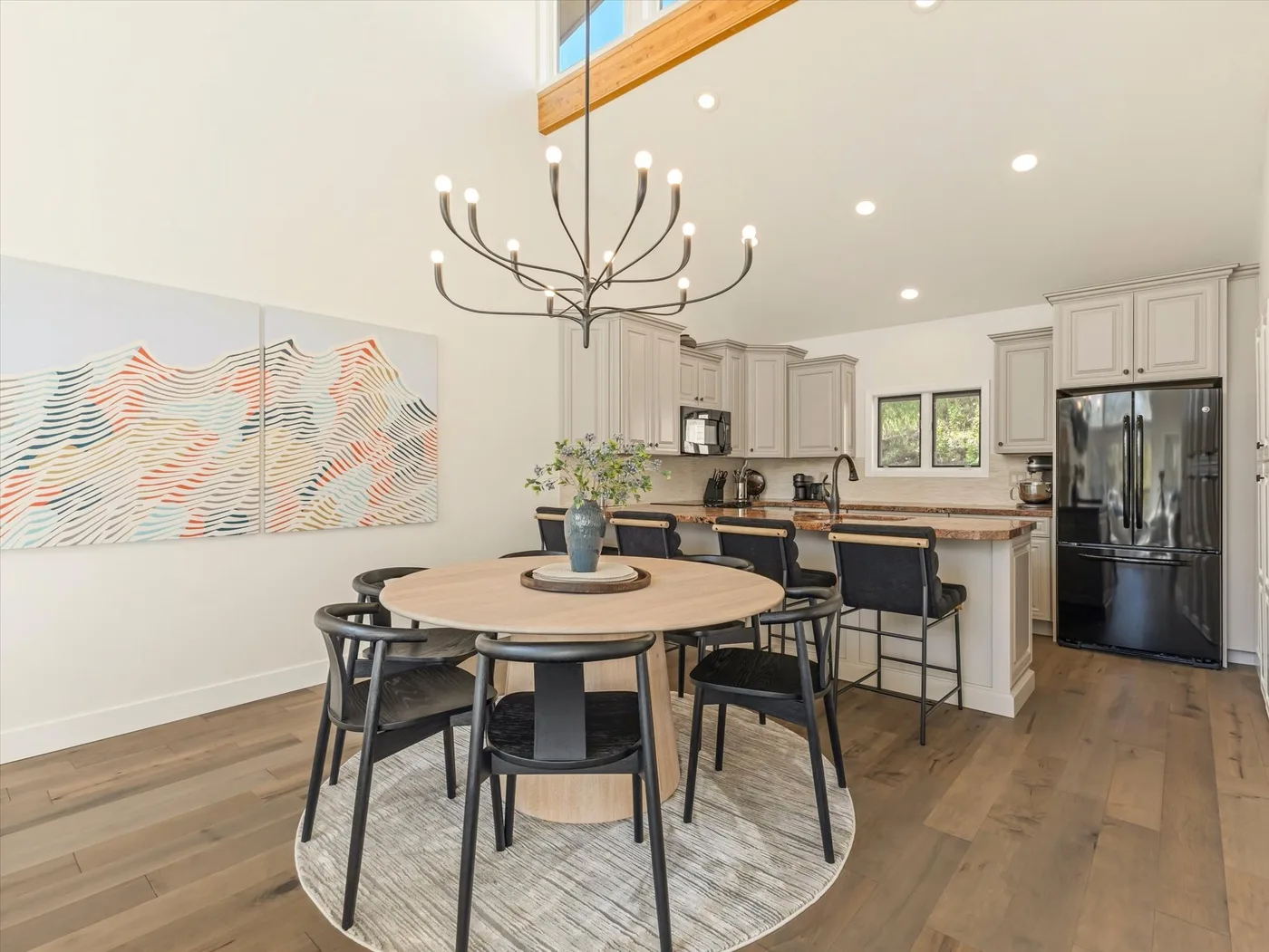 A dining area with a round table beside a kitchen island.