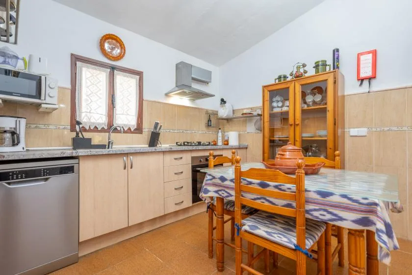 A kitchen and dining area with wooden cabinets and a table.