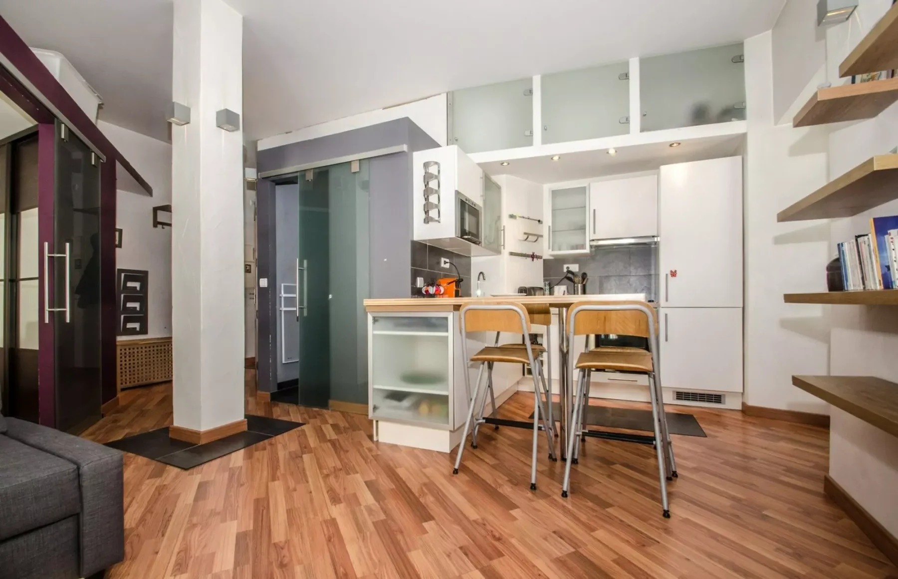 Una cocina compacta con una barra y taburetes.